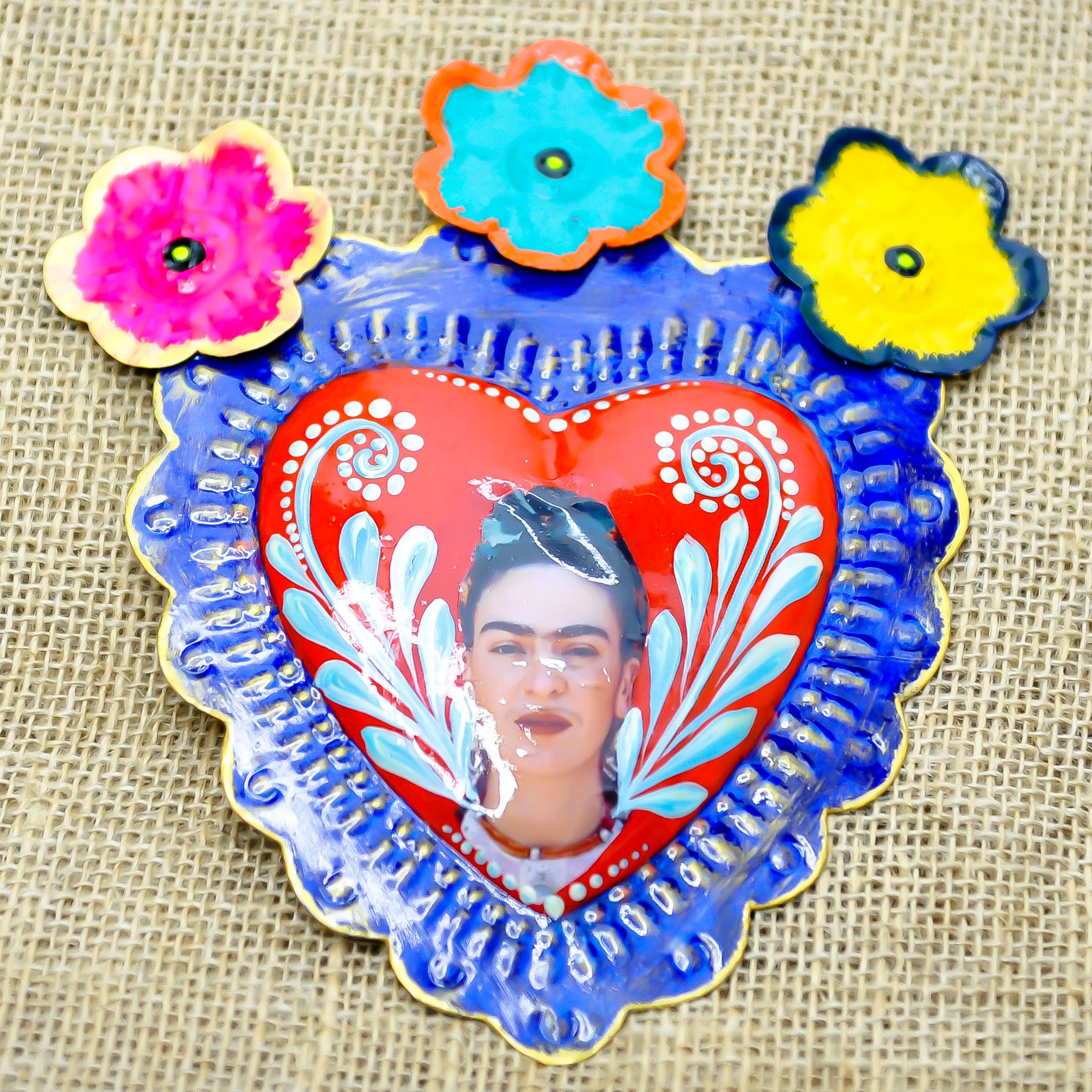 Cœur exvoto mexicain – portrait de Frida Kahlo sur fond rouge avec fleurs colorées